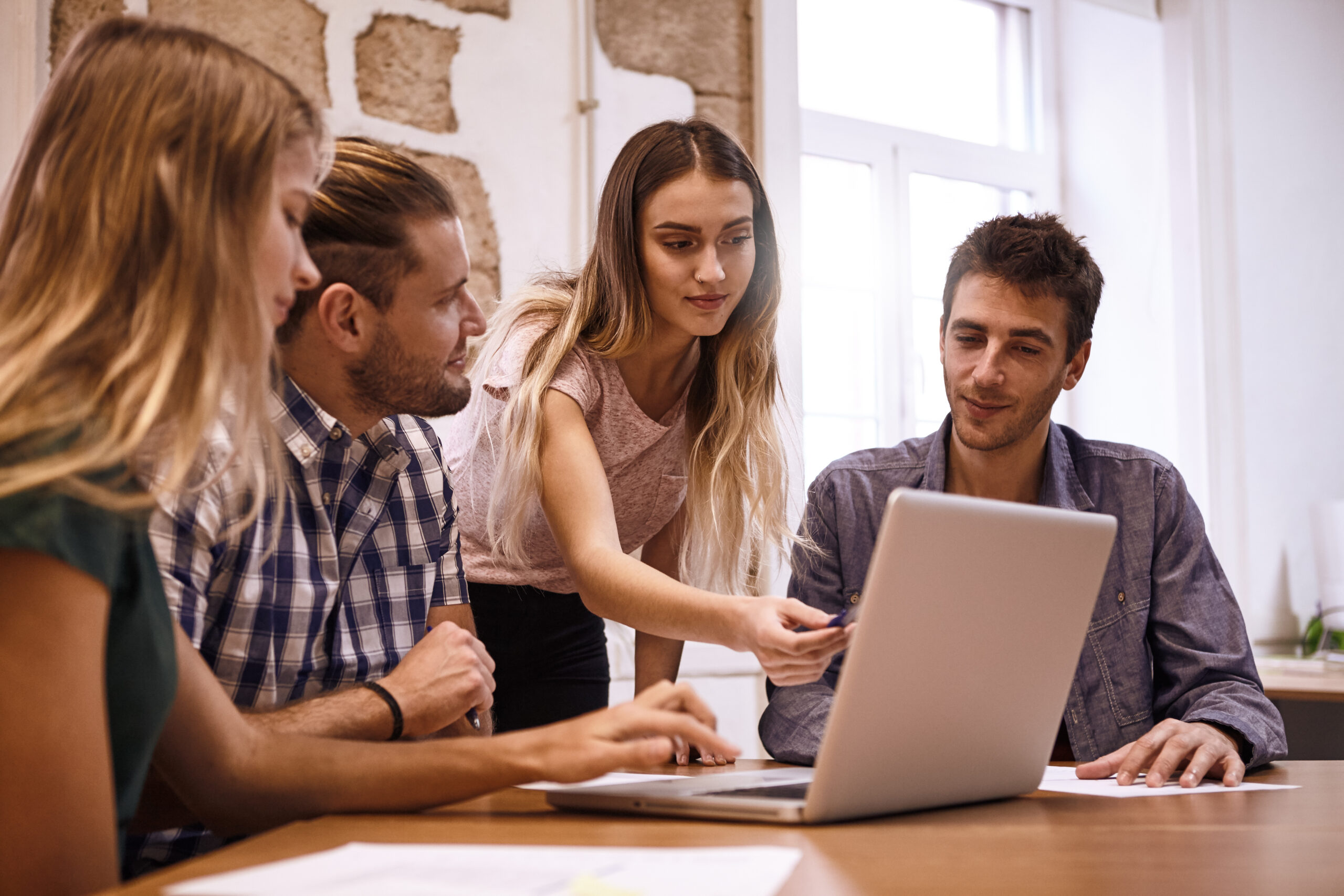 business-colleagues-discussing-ideas-around-laptop